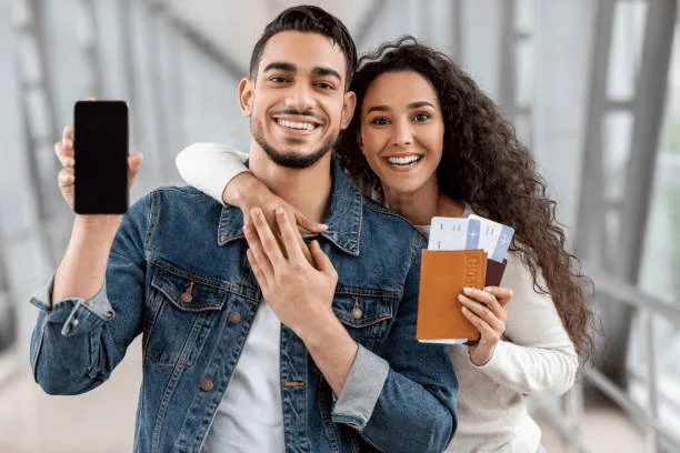 Imagen de una pareja feliz con boletos de avión en mano