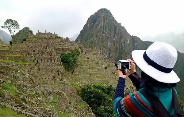 Turista capturando una fotografía de viajes en Machu Picchu